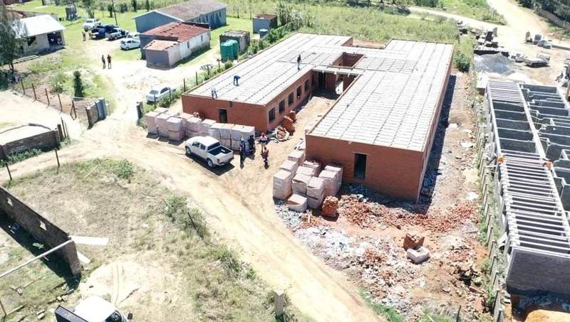 Aerial view of a construction site with a brick building under a concrete slab roof